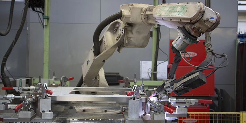 Robot hàn thanh lý đứng trên bệ thép