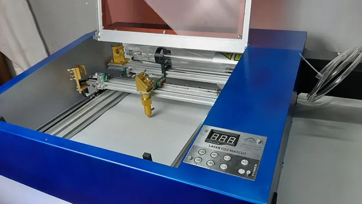 Hình ảnh mô tả không gian bên trong của máy cắt laser mini Fiber CO2 đang cắt vật liệu phi kim